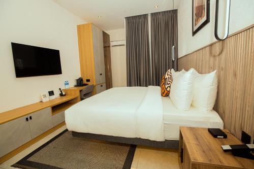 a hotel room with a bed and a television at Noble Nook Boutique Hotel Abuja in Abuja