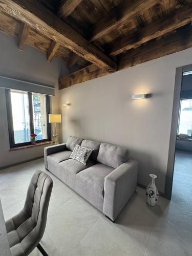 a living room with a couch and a chair at Dimora Rosaspina in Adro
