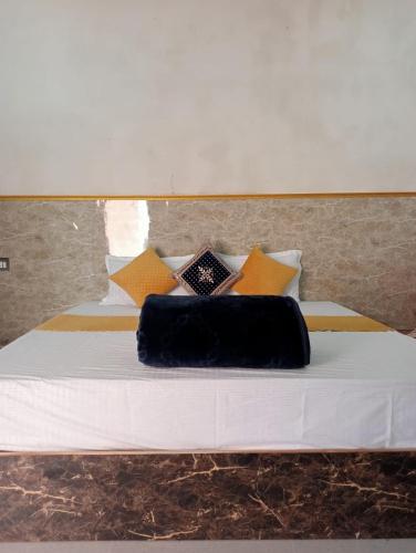 a bed with a black pillow on top of it at Shri Ramesht B & B , home stay in Varanasi