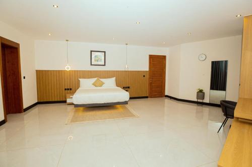 a large bedroom with a bed and a table at Noble Nook Boutique Hotel Abuja in Abuja