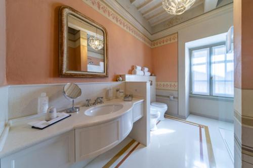 a bathroom with a sink and a mirror and a toilet at Residenza d'epoca Luca Pacioli in Sansepolcro