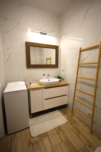 a bathroom with a sink and a mirror at Apartament LUX in Zator
