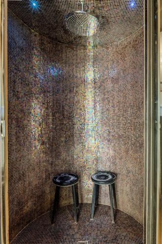 two stools in a shower with a tiled wall at Villa Aurora in Trecastelli