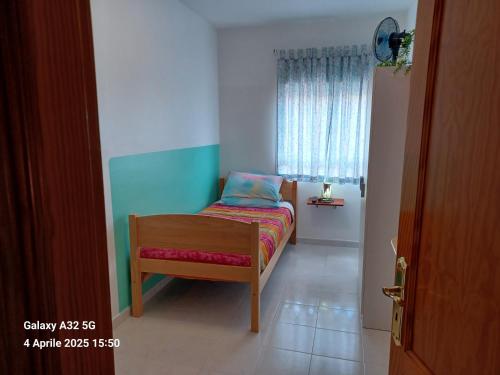 a small bedroom with a bed and a window at Habitaciones Gioly in Puerto del Rosario