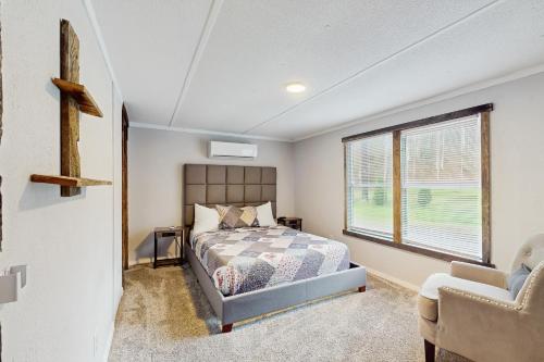 1 dormitorio con 1 cama y 1 cruz en la pared en Manis Hollow, en Gatlinburg