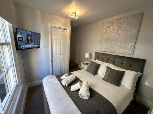 a bedroom with a large bed with pillows and a television at City Guesthouse in Oxford