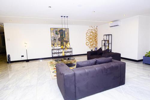 a living room with a purple couch and chairs at Noble Nook Boutique Hotel Abuja in Abuja