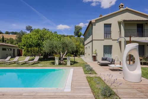 a villa with a swimming pool and a house at Villa Aurora in Trecastelli