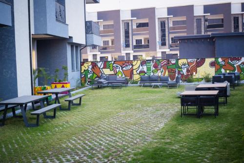 a group of tables and benches in a building with graffiti at Noble Nook Boutique Hotel Abuja in Abuja