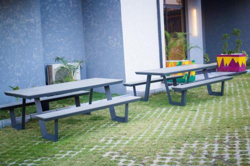 three picnic tables sitting in the grass in a room at Noble Nook Boutique Hotel Abuja in Abuja