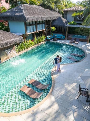 イタカレにあるTerra Boa Hotel Boutiqueのスイミングプール横に立つ男女