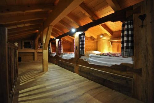 a room with three beds in a wooden cabin at Grand Chalet - Coeur de la montagne in Mont-Saxonnex