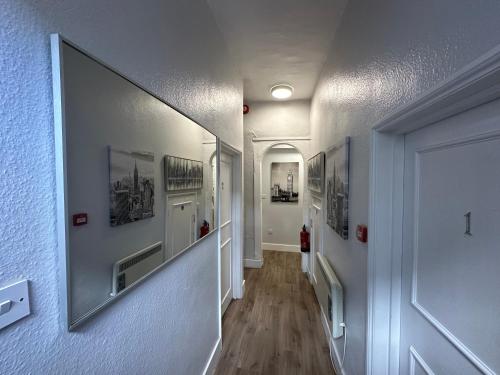 a hallway with pictures on the walls of a house at City Guesthouse in Oxford