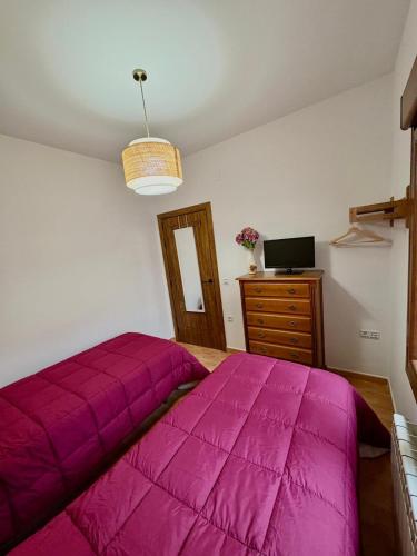 a bedroom with a large pink bed and a dresser at Alojamiento rural La Dama del Quijote 2 in El Toboso