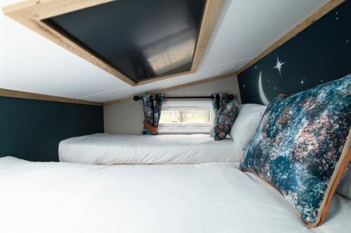 two beds in a small room with a window at Billing Aquadrome Holiday Park in Great Billing