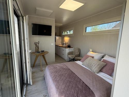 a bedroom with a bed and a bathroom with a sink at Tiny Tännle in Rust