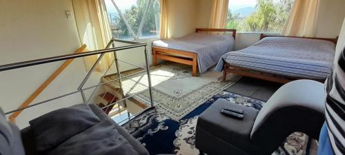 a living room with a couch and a bed and a window at Reserva de Santa Ines Valle de Tibasosa in Tibasosa