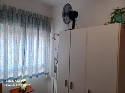 a white cabinet next to a window with a fan at Habitaciones Gioly in Puerto del Rosario