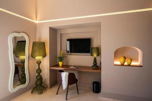 a room with a desk with a lamp and a mirror at Antalia Boutique Hotel in Positano