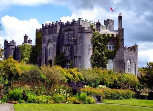 an old castle with a garden in front of it at Deerpark Stables in Highstreet