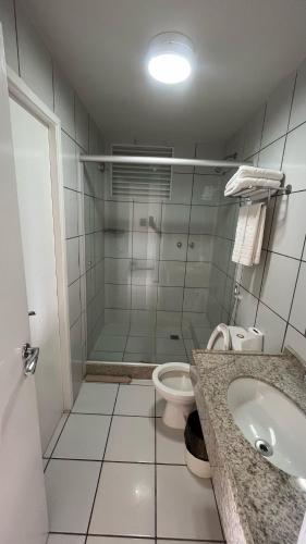 a bathroom with a shower and a sink and a toilet at Gran Lençóes Flat Residence in Barreirinhas