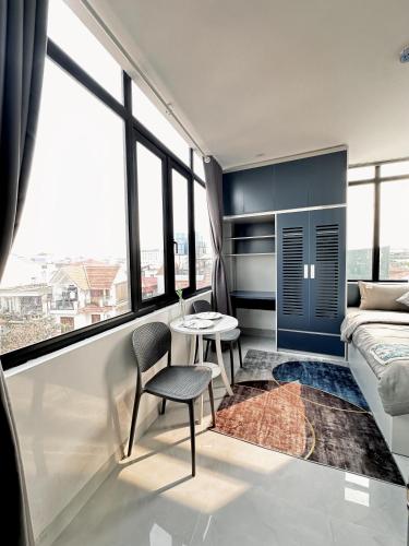 a room with a bed and a table and a chair at The Little Hanoi - Cool Apartment - Lakeside in Hanoi