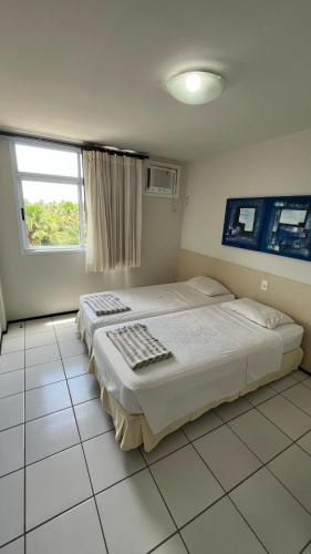 a bedroom with two beds and a window at Gran Lençóes Flat Residence in Barreirinhas