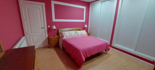a pink bedroom with a bed with a pink blanket at La casa de San Miguel in Villalpando
