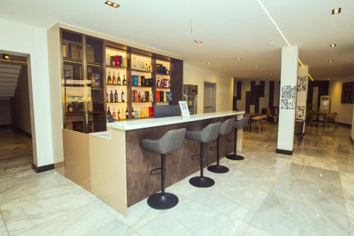 a bar with stools in a room with alcohol at Noble Nook Boutique Hotel Abuja in Abuja