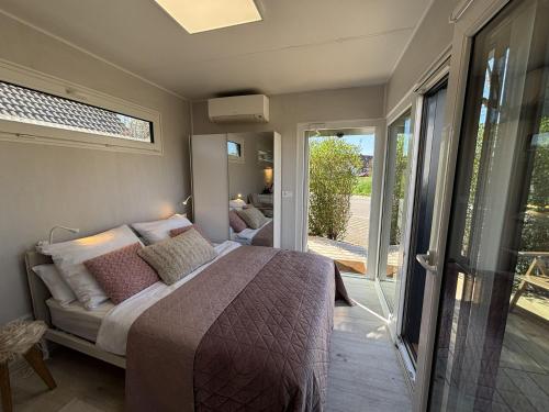 a bedroom with two beds and a sliding glass door at Tiny Tännle in Rust