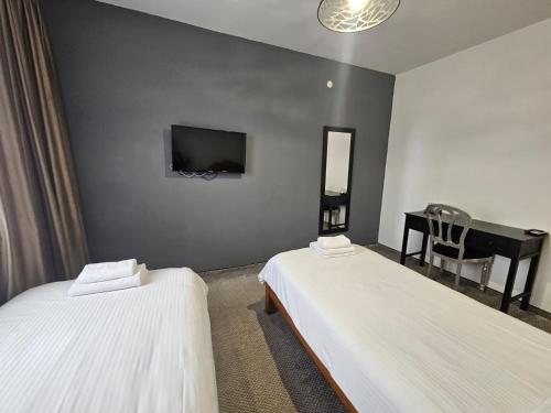 a hotel room with two beds and a piano at Meteor Central in Cluj-Napoca