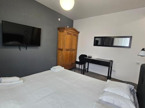 a bedroom with a bed and a desk and a television at Meteor Central in Cluj-Napoca