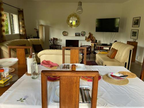a living room with a table and chairs and a tv at Appart Cozy Ivandry dans villa in Antananarivo