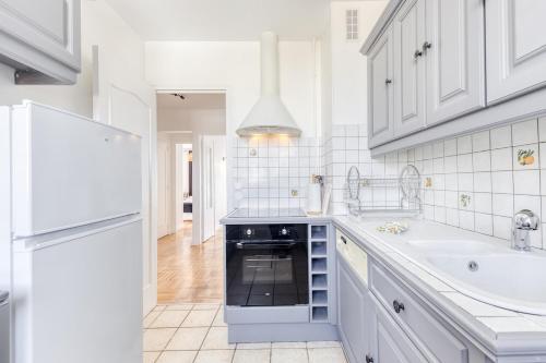 a white kitchen with a sink and a dishwasher at La Dolce Vita aux portes de Paris in Vitry-sur-Seine
