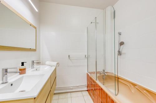 une salle de bain avec un lavabo et une douche dans l'établissement La Dolce Vita aux portes de Paris, à Vitry-sur-Seine