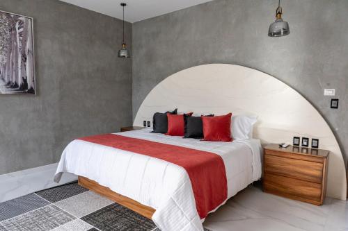 a bedroom with a large bed with red pillows at La Cascada Hotel Boutique in Juanacatlán
