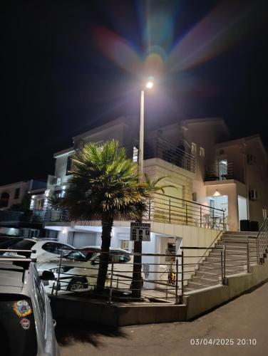 a street light in front of a building with a palm tree at Villa Sun Budva in Budva