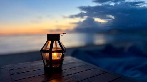 a candle in a glass bottle sitting on a table at Sunny Rose Bungalows Gili Air - Adults only in Gili Air