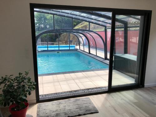 une piscine vue à travers une fenêtre en verre dans l'établissement l'ensemblière, à Plérin
