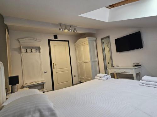 a white bedroom with two beds and a desk at Meteor Central in Cluj-Napoca