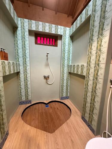 a room with a shower and a wooden floor at Sunny Rose Bungalows Gili Air - Adults only in Gili Air