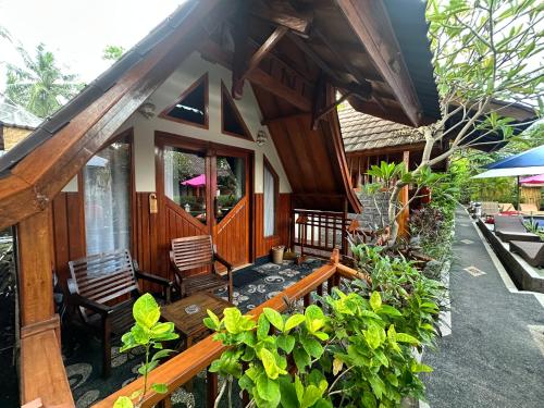 a house with two chairs and a porch at Sunny Rose Bungalows Gili Air - Adults only in Gili Air