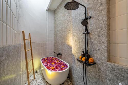 a bathroom with a bath tub filled with sprinkles at A9 - Exclusive 3-Bedroom Villa in Seminyak with a Rooftop Paradise in Kerobokan