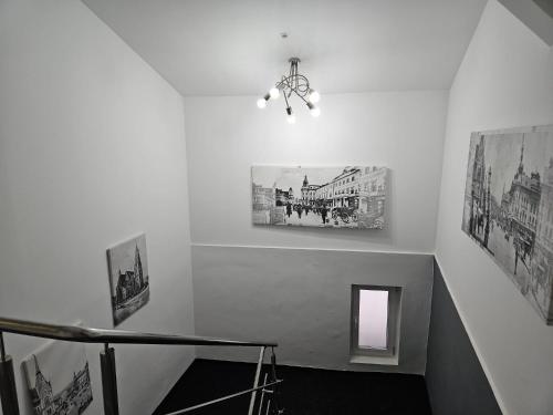 a staircase with two pictures on the wall and a chandelier at Meteor Central in Cluj-Napoca