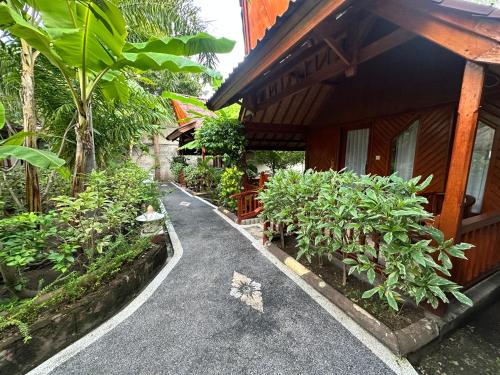a walkway next to a building with trees and plants at Sunny Rose Bungalows Gili Air - Adults only in Gili Air