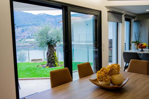 a dining room with a table and a large glass window at Casa das Oliveiras in Vieira do Minho