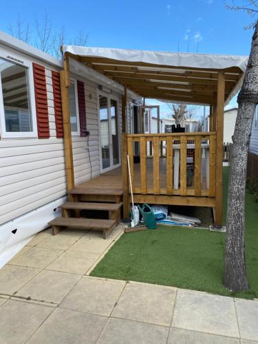 a porch of a house with a wooden deck at Mobilhome bord de mer in Le Grau-dʼAgde