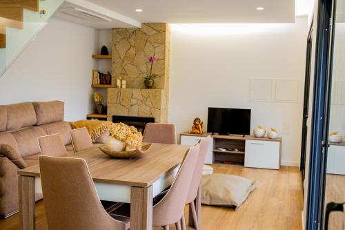 a living room with a wooden table and chairs at Casa das Oliveiras in Vieira do Minho