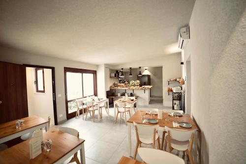 a dining room with wooden tables and white chairs at Palermo Inn Boutique Hotel in Palermo