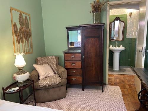 a bathroom with a chair and a dresser and a sink at Casa Vintage in Ouro Preto